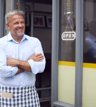 Portrait Of Male Owner Or Staff Standing Outside Coffee Shop
